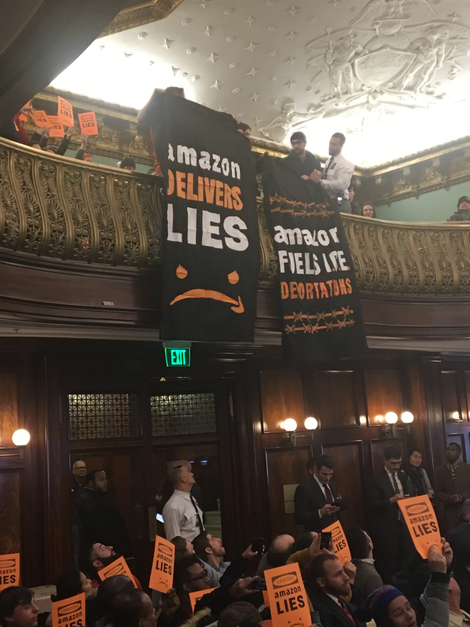 Protesters dropping banners from the City Hall balcony